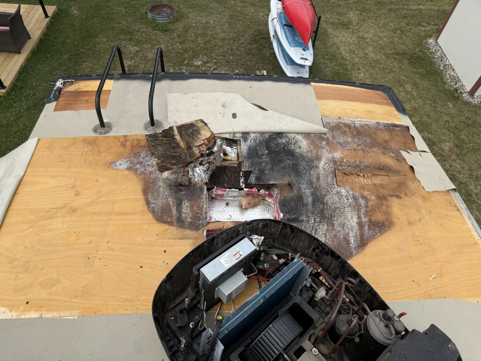 RV roof with damaged material and exposed decking after water intrusion